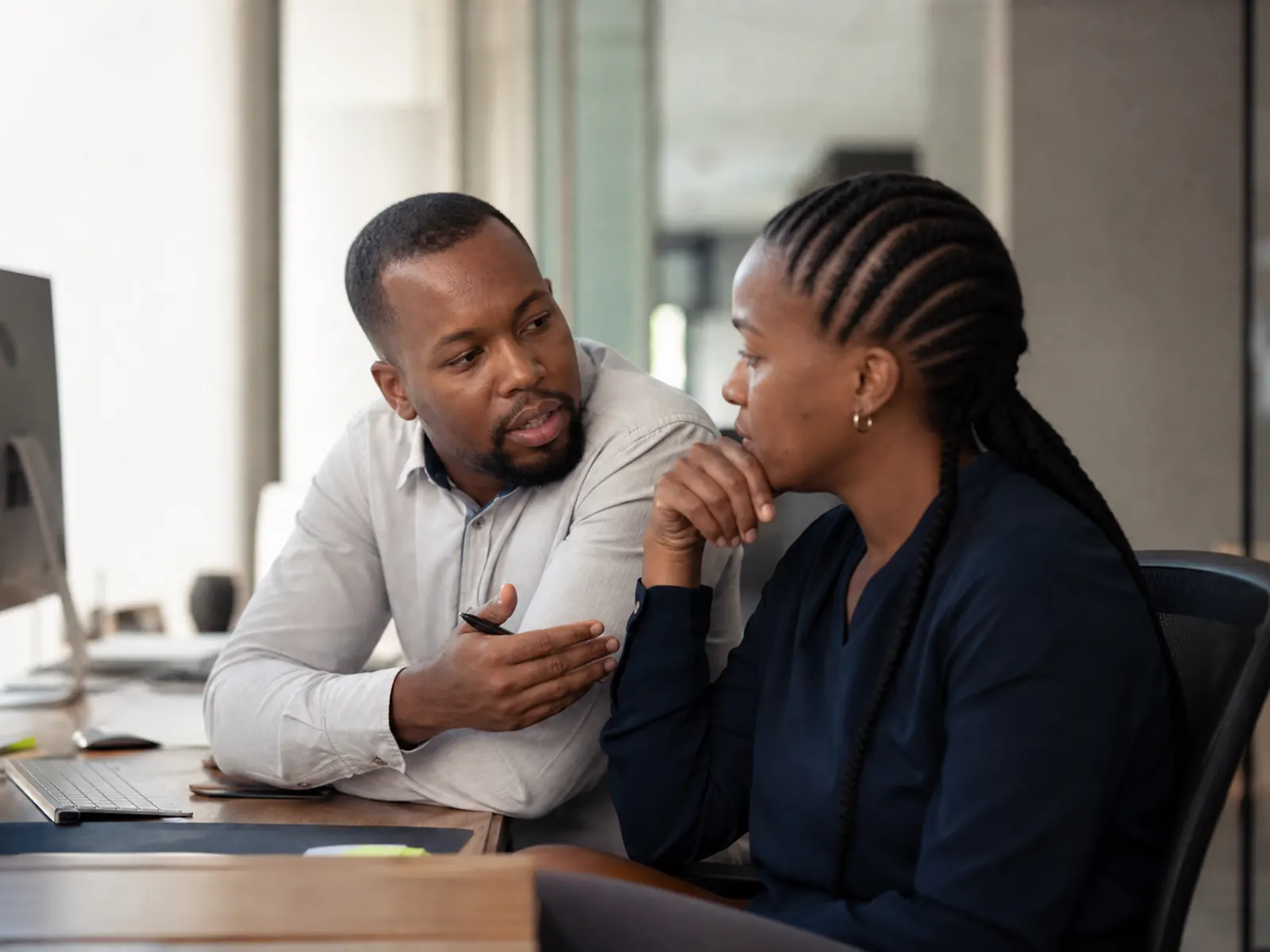 A leader mentors a colleague one-on-one, a genuine coaching moment mid-conversation.